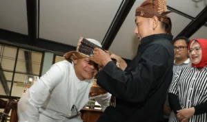 Ganjar Pranowo diangkat menjadi bagian keluarga Solihin GP dengan ditandai pemberian ikat Barangbang Semplak bermotif kujang oleh salah satu anggota Solihin GP, Rabu 4 Oktober 2023.