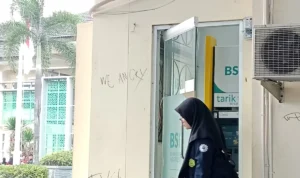 Seorang mahasiswi UIN Bandung keluar dari ATM BSI UIN Bandung.