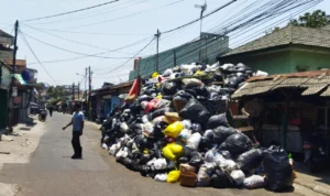 MENGGUNUNG: Tumpukan sampah membeludak hingga setengah ruas Jalan Kaptel Abdul Hamid, Cidadap, Kota Bandung, pada Selasa (17/10). (Nizar/Jabarekspres)
