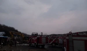 Alat berat dan petugas saat melakukan pemadaman api di TPA Cikundul, Kota Sukabumi.
