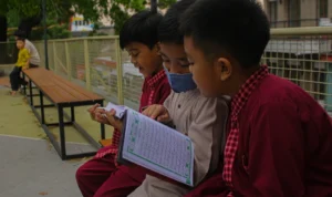 Tiga anak tampak melantunkan ayat suci Alquran di Teras Cihampelas, Kota Bandung di tengah sepinya para pengunjung. (PANDU MUSLIM/JABAREKSPRES)