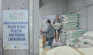 Ilustrasi. Pedagang beras tengah mengangkat sekarung barang dagangannya. (Dok.Jabarekspres)