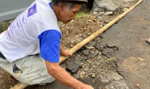 Perbaikan Jalan dari Pokir Dewan Rusak, Warga Kesal hingga Kuliti Aspal Hotmix Warga Kampung Kiara Lawang kuliti aspal yang rusak kembali, padahal satu pekan baru diperbaiki melalui pokir DPRD KBB. Senin (4/12). Foto Jabarekspres