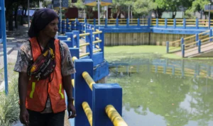 Banjir Kota Bandung, Kolam Retensi Bukan Solusi? Masyarakat sedang berjalan di Kolam Retensi Gedebage, Kota Bandung yang berfungsi sebagai jalan keluar banjir.