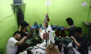 Masa Depan Kampoeng Radjoet di Tangan Anak-anak Perajin SERIUS: Perajin kain rajut saat melakukan kerja-kerja menjahit di Kampoeng Radjoet Binong Jati, Kecamatan Batununggal, Kota Bandung, pada Rabu (3/1). (Nizar/Jabar Ekspres)