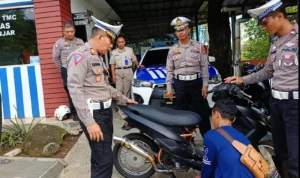Kasat Lantas Polres Banjar AKP Otong Rustandi menindak salah satu pengendara knalpot brong di Pos Polisi Jembar, Kota Banjar, Jumat 12 Januari 2024. (Cecep Herdi/Jabar Ekspres)