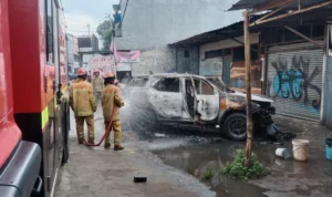 Petugas Damkar sektor Gunung Putri padamkan mobil fortuner yang terbakar, Jumat (5/1) pagi.