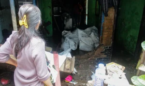 Salah satu rumah warga jebol dikarenakan debit air tinggi serta arus deras saat Sungai Cikapundung meluap di kawasan Gang Apandi, Kelurahan Braga, Kota Bandung, Jumat (12/1).