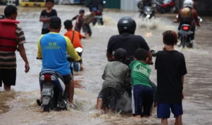 Ilustrasi: Warga Kota Bandung sedang menerjang banjir.