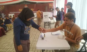 KPU Kota Sukabumi Simulasikan Pemungutan dan Penghitungan Suara, Ini Kata Peserta Salah seorang warga ketika mencelupkan jarinya ke tinta saat proses simulasi pemungutan dan penghitungan suara di KPU Kota Sukabumi.