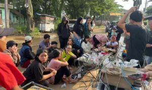 Puluhan warga saat menggunakan jasa Charge Handphone ditengah kondisi banjir dan tanpa adanya listrik di Kampung Lamajang, Desa Citeureup, Dayeuhkolot, Kabupaten Bandung, Jumat (12/1/2024). Foto Agi Jabar Ekspres
