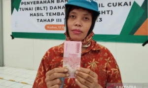seorang pekerja menunjukkan uang dari program bantuan langsung tunai (BLT) untuk buruh rokok.