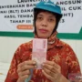 seorang pekerja menunjukkan uang dari program bantuan langsung tunai (BLT) untuk buruh rokok.