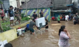 Warga Gang Apandi, Kelurahan Braga saat menyelamatkan barang berharga dari banjir bandang akibat meluapnya Sungai Cikapundung, Kamis (11/1) sore.