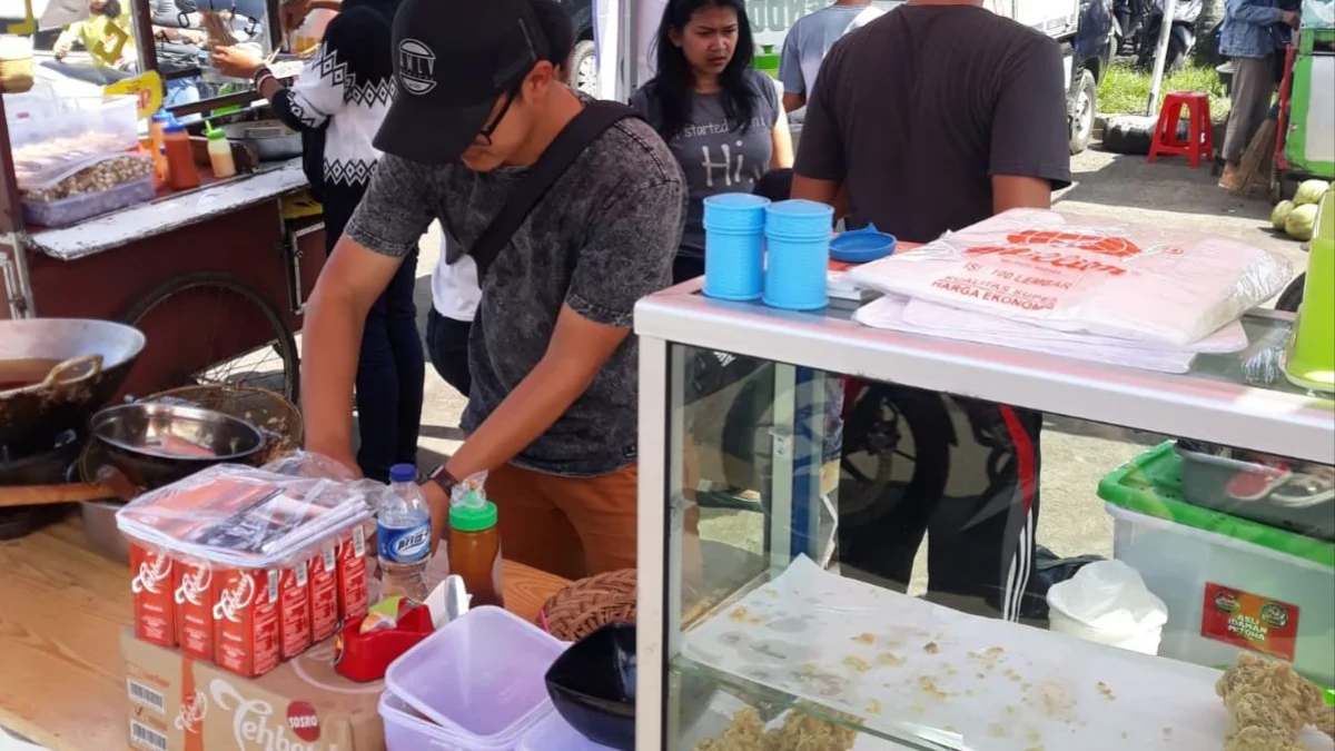 Gilang (34) pedagang ayam geprek di Padalarang, Kabupaten Bandung Barat saat melayani pembeli. Kamis (22/2). Foto Jabarekspres