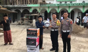 Kasat Lantas Polres Banjar AKP Otong Rustandi memberikan helm kepada santri di Ponpes Fathurrohman Desa Binangun Kecamatan Pataruman Kota Banjar, Jumat 2 Februari 2024. (Cecep Herdi/Jabar Ekspres)