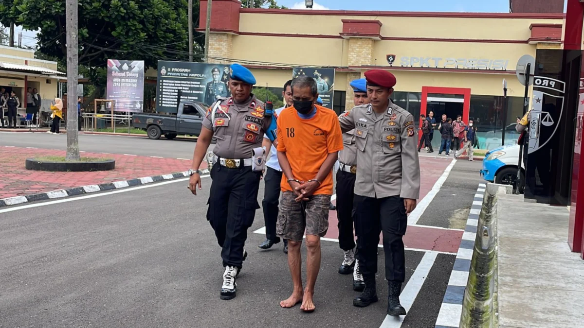 MTS (60) Seorang Pria Paruh Baya yang menanam ganja 20 batang pohon di halaman rumahnya saat digiring ke Mapolresta Bandung, Senin (12/2/2024).