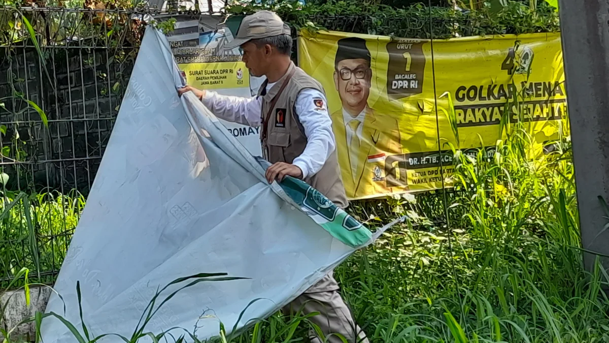 Petugas gabungan Satpol PP, Bawaslu, dan Panwascam saat bersihkan APK yang masih terpasang di masa tenang Pemilu 2024.