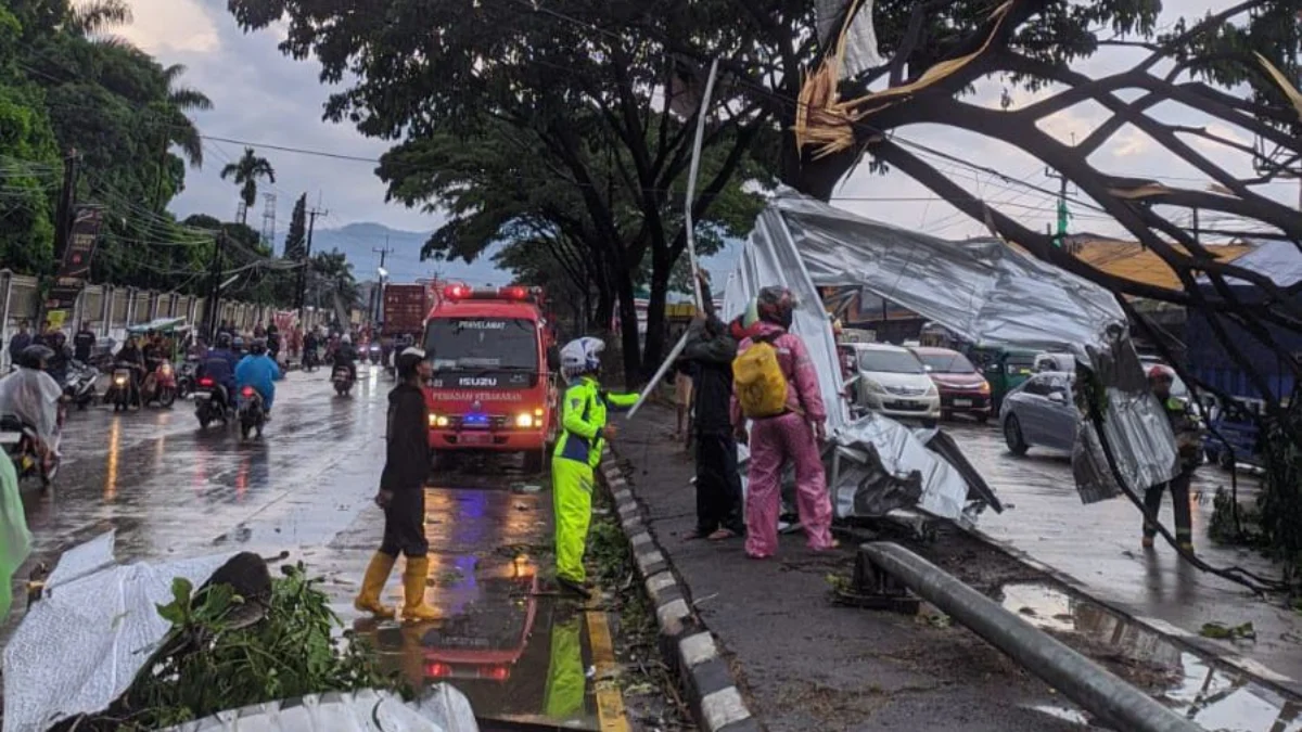 Dampak Puting Beliung, Jalan Raya Bandung-Garut Terhenti Petugas saat mengevakuasi puing reklamu dan pohon tumbang yang menghalangi jalan Raya Bandung-Garut. Foto Istimewa