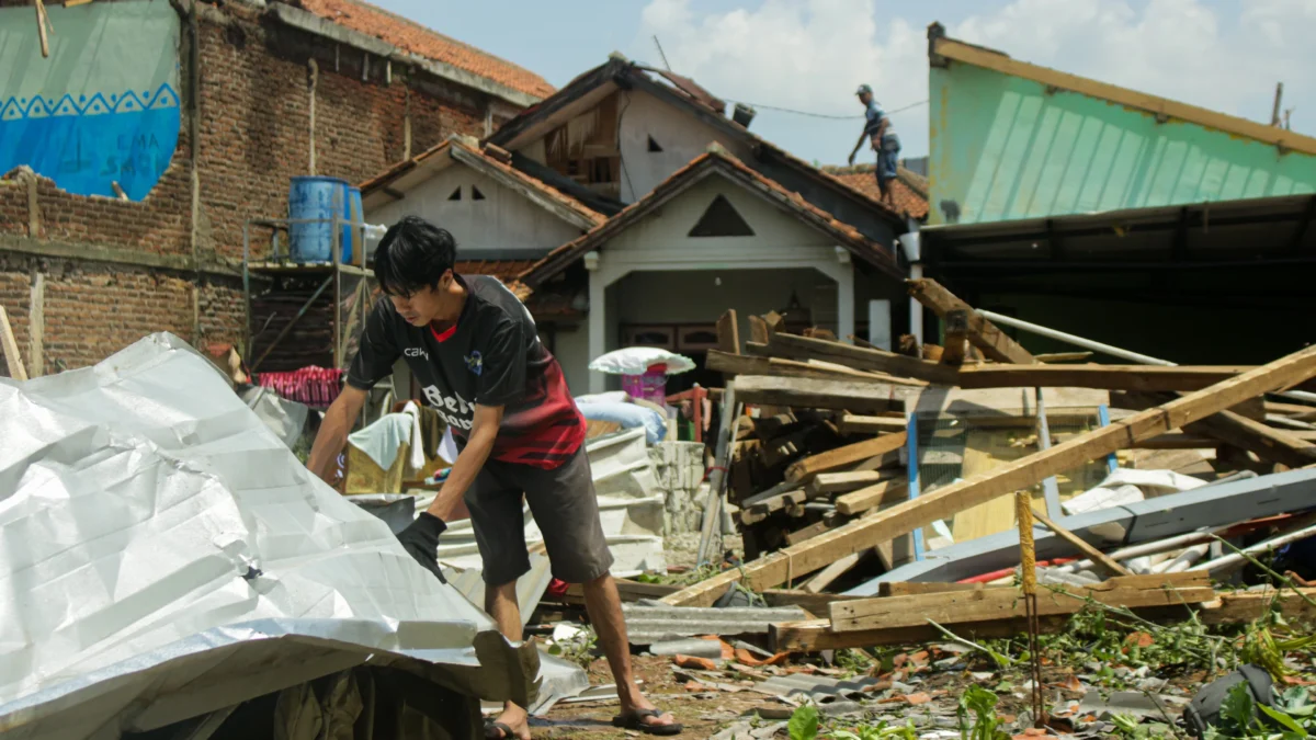 Warga membersihkan sisa puing bangunan yang diterjang Tornado di Desa Sukadana, Kecamatan Cimanggung, Kabupaten Sumedang. (Pandu Muslim/Jabar Ekspres)