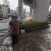 Dok. Warga melintas di jalan yang terendam banjir (Antara)