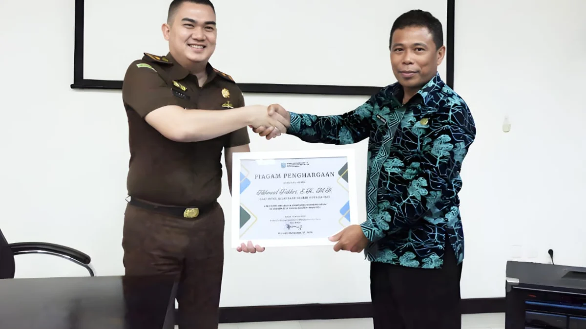 Kepala Seksi (Kasi) Intelejen Kejaksaan Negeri Banjar Akhmad Fakhri SH MH (kiri), menerima penghargaan dari Kepala DPMD Kota Banjar Wawan Gunawan SP MSi atas terselenggaranya program Jaga Desa di Kota Banjar. (istimewa)