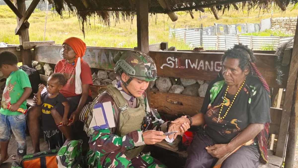 Salah satu prajurit Buaya Putih Kostrad saat mengecek kesehatan beberapa warga Distrik Sinak, Kabupaten Puncak, Rabu 13 Maret 2024. (Istimewa)