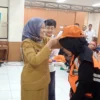 Doc. Asisten Administrasi Umum Dr. Maria Fitriana saat Menyematkan Seragam pada Juru Parkir (mong)