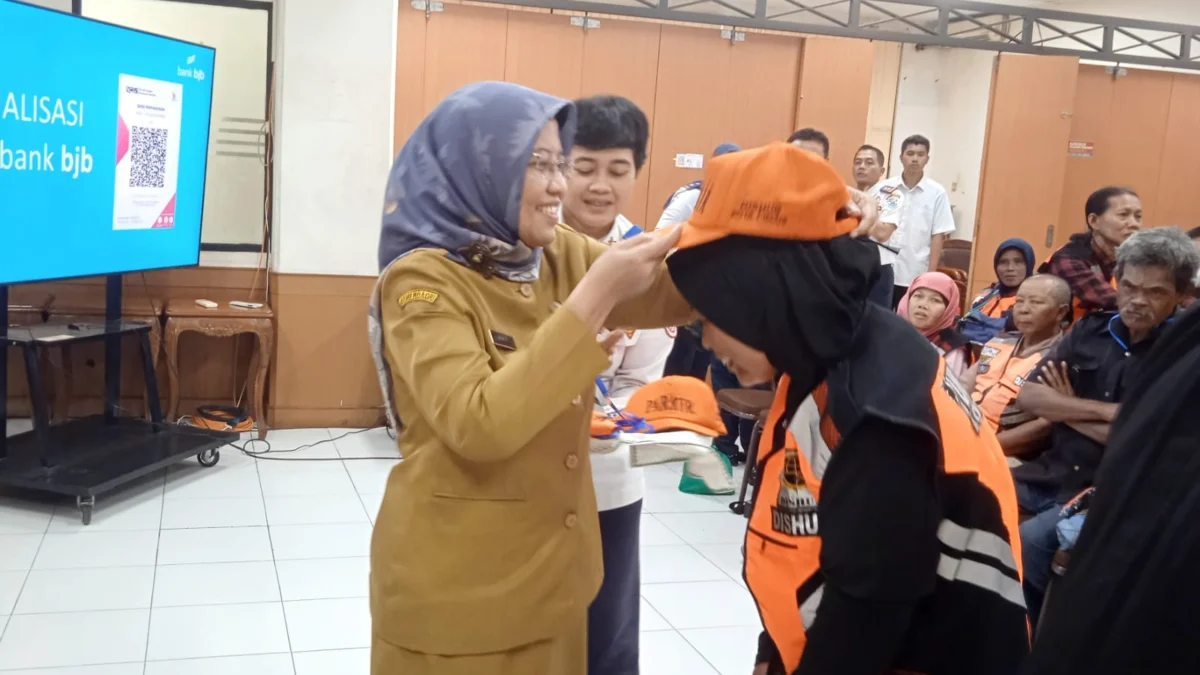 Doc. Asisten Administrasi Umum Dr. Maria Fitriana saat Menyematkan Seragam pada Juru Parkir (mong)