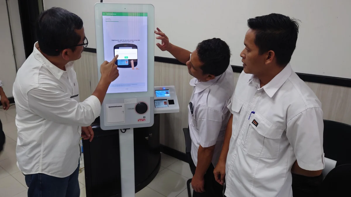 Kepala P3DW Kota Banjar, Benny Suranata (kiri) menunjukkan cara kerja mesin Anjungan Digital Mandiri (ADM) atau Samsat Digital kepada salah satu pejabat ASN di Kota Banjar, Rabu 20 Maret 2024.