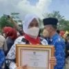 DUGAAN PENYELEWENGAN DANA BOS: Kepala UPTD SMPN 3 Banjar, Nia Kurniasih, memegang piagam penghargaan Adiwiyata tingkat Nasional.