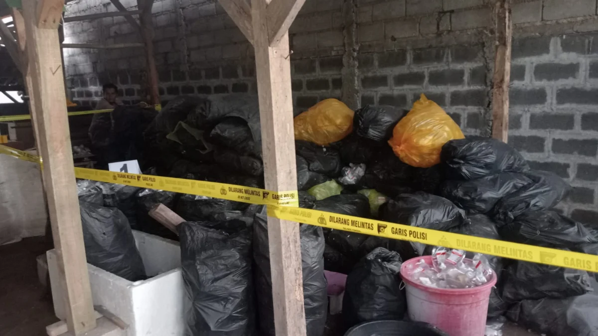 Anggota Polsek Pataruman memasang garis polisi (police line) di lokasi pengolahan limbah infus milik yayasan di wilayah Tanjungsukur, Kota Banjar.