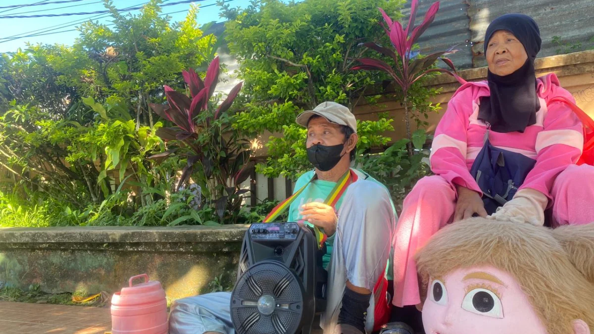 Sepasang suami isteri yang tengah beristirahat sehabis keliling menjadi badut. Riki Achmad/Jabar Ekspres