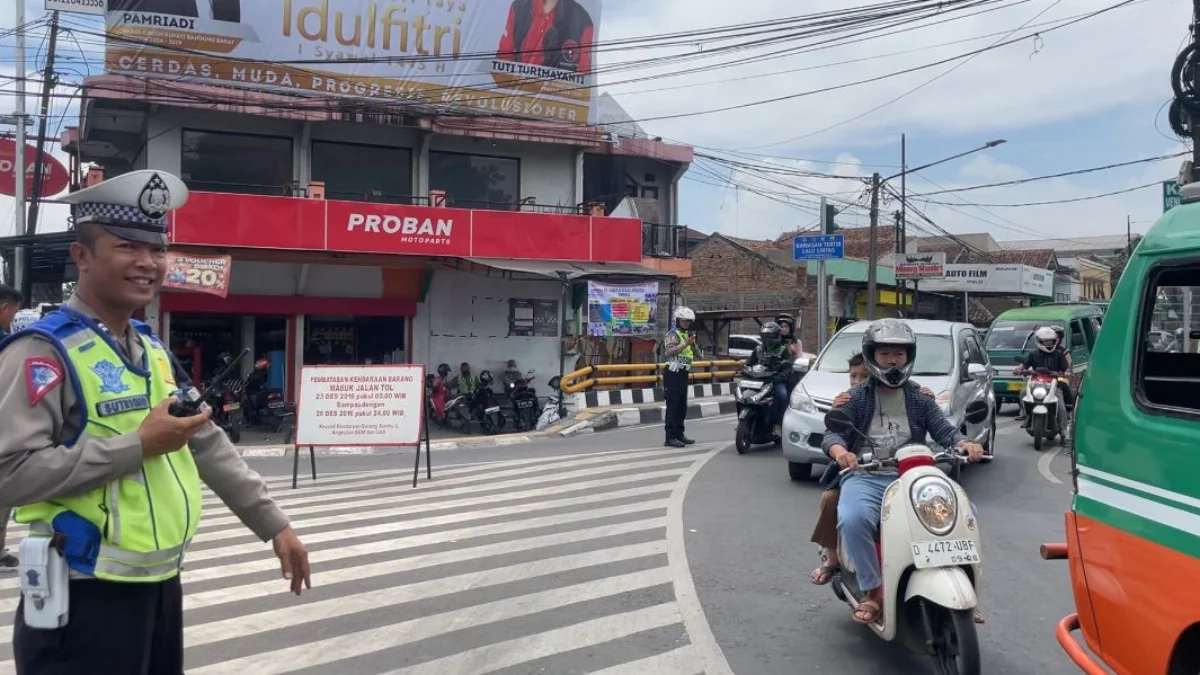 Petugas kepolisian tengah mengatur lalu lintas di Simpang Tol Padalarang, Bandung Barat. Senin (8/4). Foto Jabarekspres