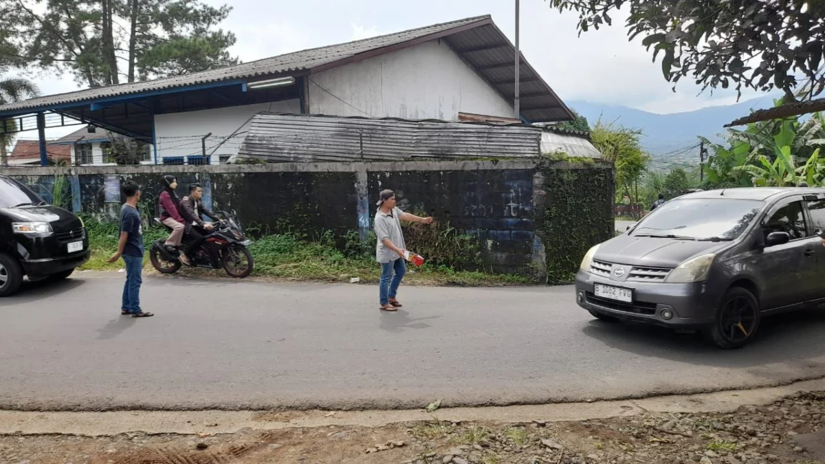 TOL BOCIMI LONGSOR: Pak Ogah saat mengatur lalu lintas di jalan alternatif Warung Ceuri, Desa Pondokkasolandeuh, Kecamatan Parungkuda, Kabupaten Sukabumi.