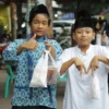Ilustrasi: Dua anak-anak (bocil) riang usai berhasil membeli makanan saat berburu menu takjil Ramadan di area Alun-Alun Ujungberung, Kota Bandung.