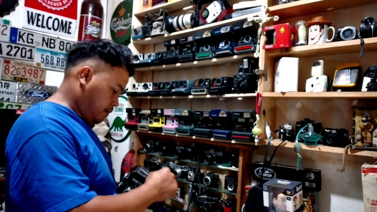 Pasar Antik Cikapundung Masih Eksis, Surga Pemburu Barang Vintage Yosep Tobing sedang membersihkan koleksi kamera jadul miliknya di Pasar Antik Cikapundung.