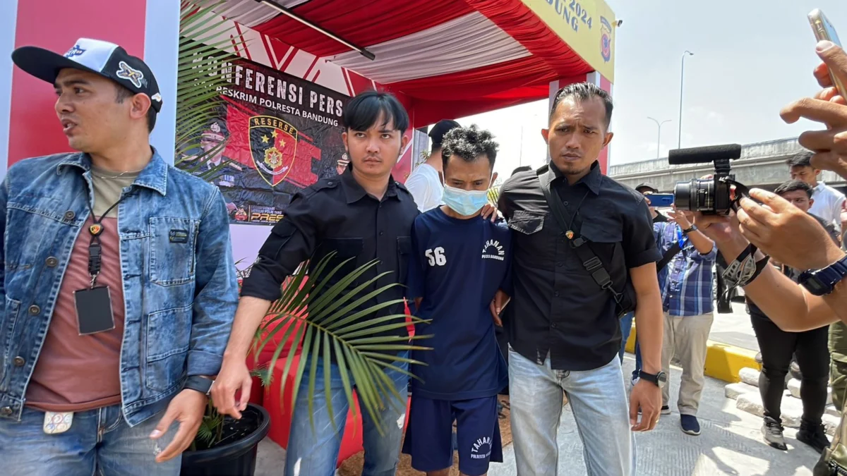 Mulyadi alias Ujang alias Ubro (31) yang lakukan penganiayaan kepada anaknya hingga meninggal dunia saat digiring pihak kepolisan dalam ungkap kasus polresta bandung di Pos Pam Terpadu Cileunyi, Kabupaten Bandung, Minggu (7/4/2024). Foto Agi Jabar Ekspres