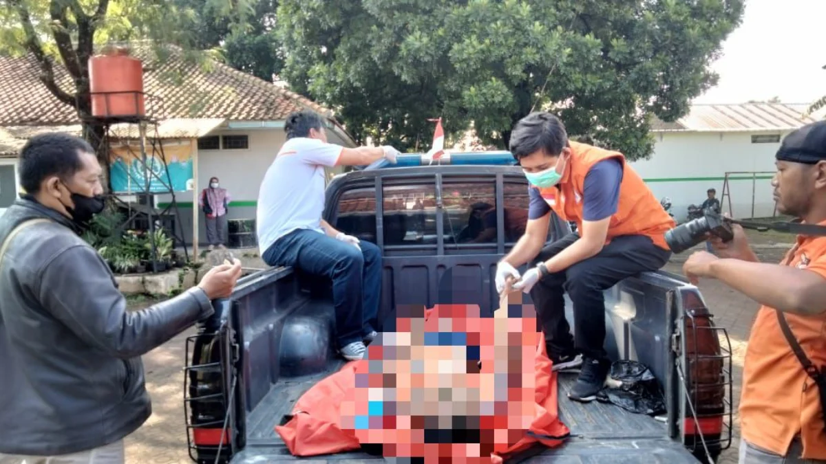 Petugas kepolisiaan saat mengevakuasi seorang pria tanpa identitas yang ditemukan Gantung diri di Pemakaman Umum di Paledang, Ciparay, Selasa (2/4/2024). Foto Istimewa