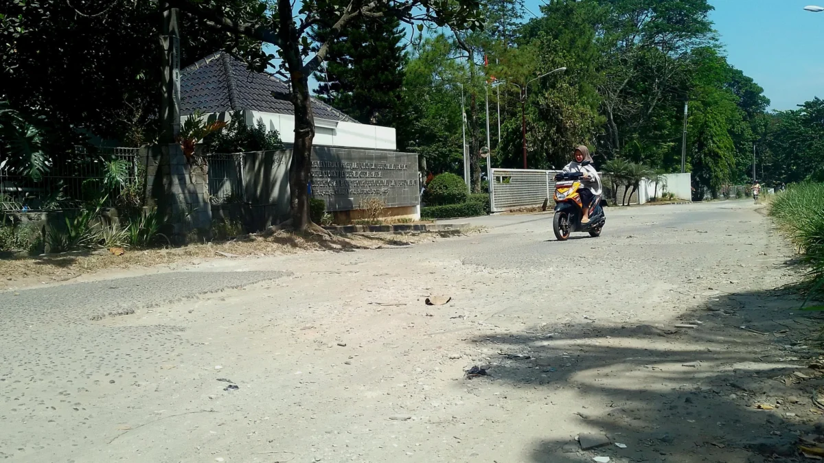 Jalan kabupaten di kawasan Kantor Direktorat Bina Teknik Perumahan dan Permukiman Kementerian Pekerjaan Umum dan Penataan Ruang (KemenPUPR), wilayah Desa Cileunyiwetan, Kecamatan Cileunyi, Kabupaten Bandung kondisinya rusak dan minim PJU. (Yanuar/Jabar Ekspres)