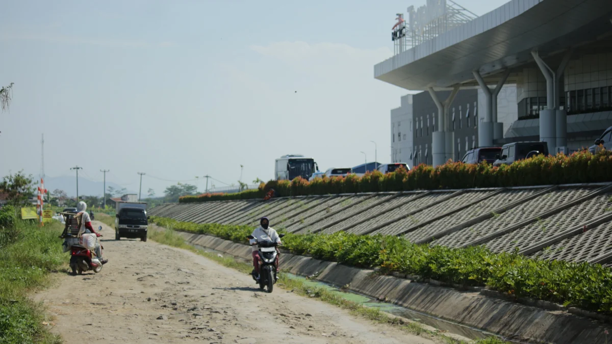 Sejumlah kendaraan melintasi jalan rusak di kawasan Stasiun Kereta Cepat Tegalluar, Kampung Cipanileman, Cibiru Hilir, Kabupaten Bandung, Selasa(7/4). (Pandu Muslim/Jabar Ekspres)
