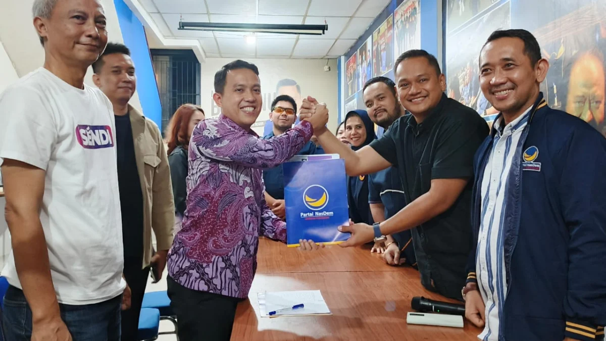 Sendi Fardiansyah saat menyerahkan formulir pendaftaran penjaringan Bacawalkot Bogor kepada Ketua DPD Partai Nasdem, Benninu Argobie. (Yudha Prananda / Jabar Ekspres)