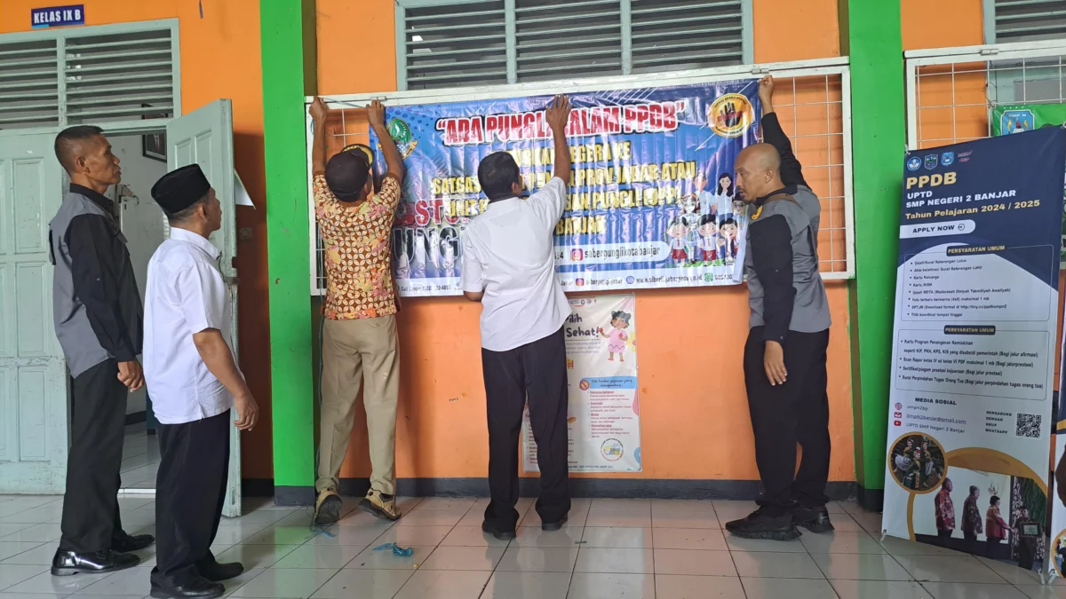 Tim Saber Pungli Kota Banjar bersama pihak sekolah memasang spanduk himbauan terkait larangan praktik pungli dalam pelaksanaan PPDB di sekolah, 12 Juni 2024. (Istimewa)