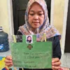 Siti, sang ibu saat memperlihatkan foto serta biodata putrinya yakni Nabila yang diduga menjadi korban aksi perundungan di Bandung Barat. Dok istimewa