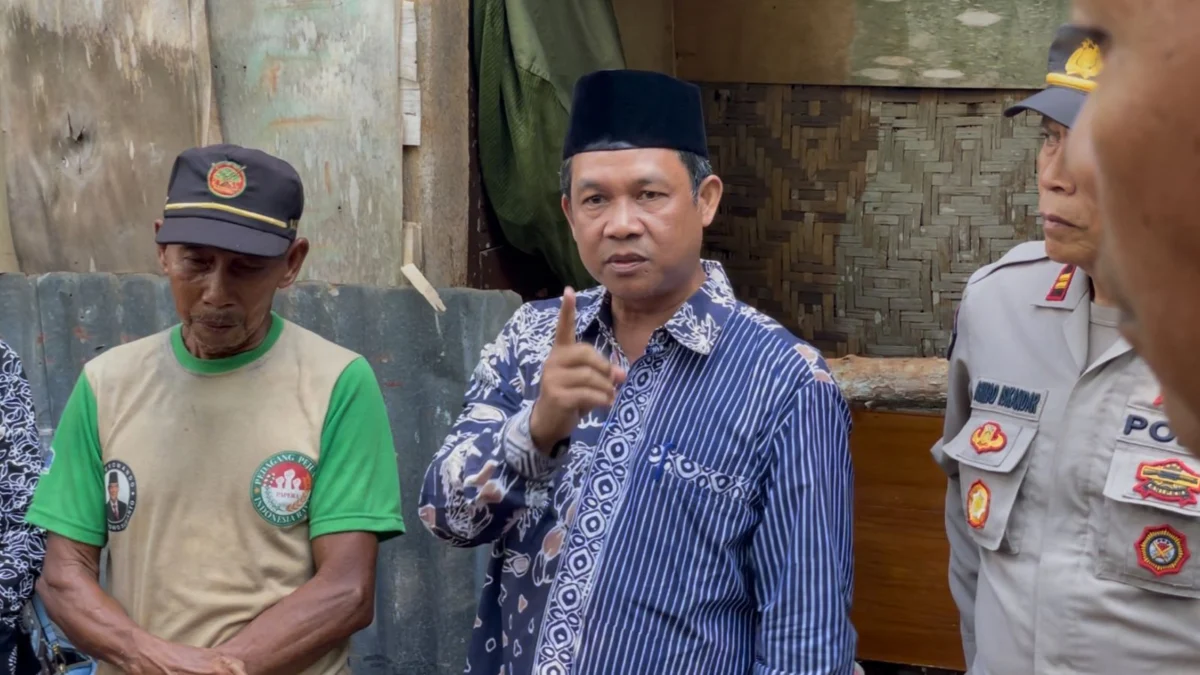 Kabag Kesra Setda Kota Banjar Agus Mulyana (tengah) mengunjungi Engkus Kusnadi (kiri) di depan gubuk yang ditempati Engkus bersama istri di wilayah Purwaharja Kota Banjar Jawa Barat, Kamis 20 Juni 2024. (Cecep Herdi/Jabar Ekspres)