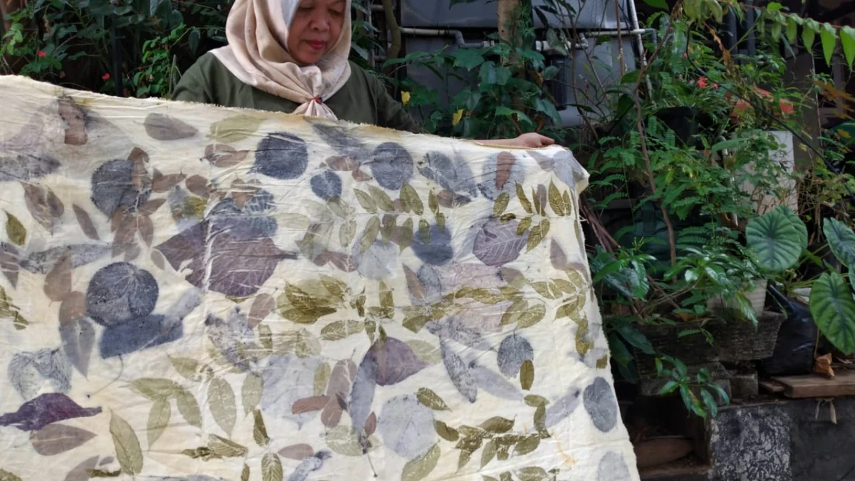 SEJUK : Teti Herlina menunjukkan kain hasil ecoprint yang diproduksinya, Kamis (27/6).(Hendrik Muchlison)