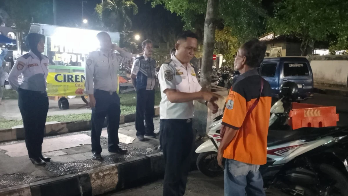 Pegawai dari Dinas Perhubungan Kota Banjar saat mengimbau salah satu juri parkir yang menunggak setoran retribusi di salah satu ruas jalan di Kota Banjar, Senin 10 Juni 2024 malam. (Cecep Herdi/Jabar Ekspres)