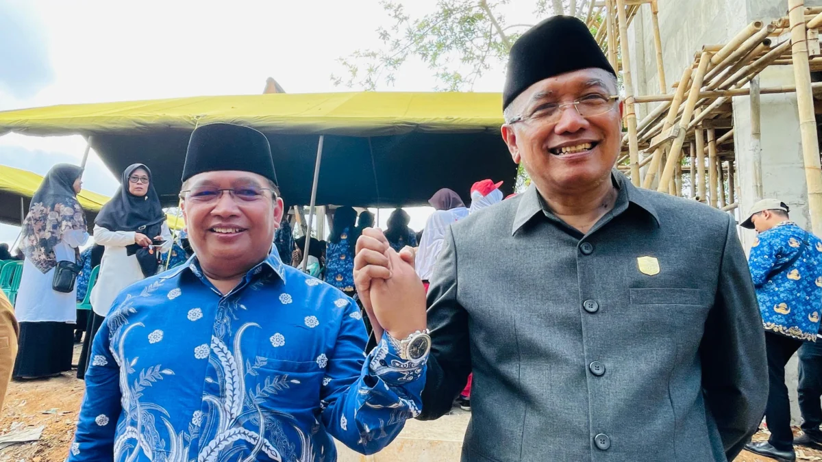 H Sudarsono (kanan) dan H Bambang Hidayah (kiri) saling berjabat tangan di Lembah Pejamben Desa Binangun Kota Banjar usai acara pengibaran bendera merah putih raksasa, Rabu 17 Juli 2024. (Cecep Herdi/Jabar Ekspres)