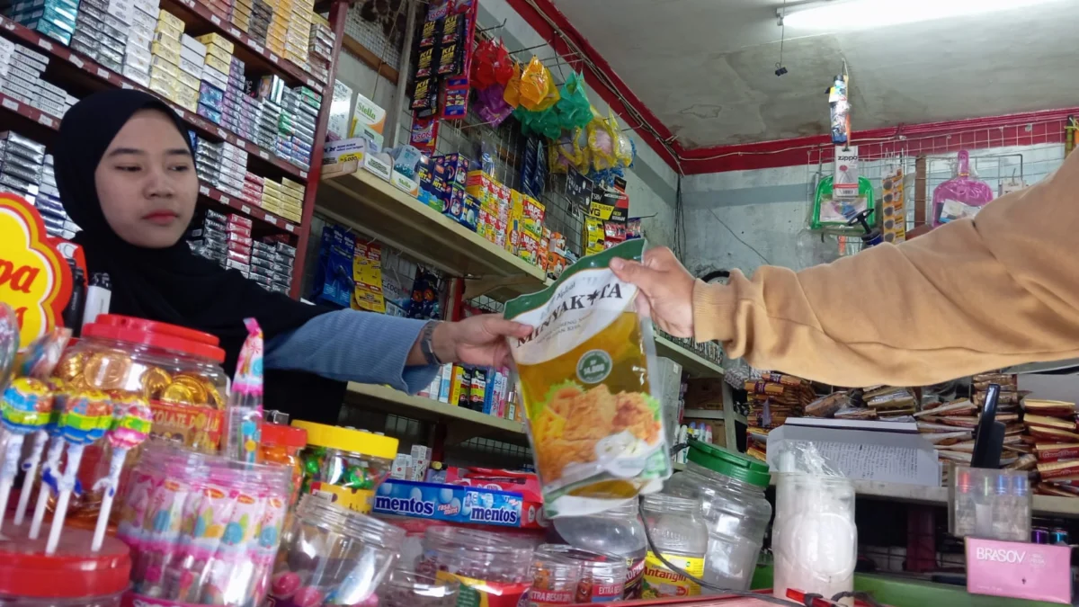 Desak Pemerintah Sorot Harga Minyak Kita di Kota Bandung Seorang penjaga toko sedang melayani pembelian minyak goreng bersubsidi Minyak Kita, di Margahayu, Kota Bandung. (Nizar/Jabar Ekspres)