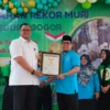 Kepala SMA Kosgoro Kota Bogor, Herman Lasrin (Kanan) saat menerima Piagam Penghargaan Rekor MURI atas karya siswa-siswinya, Rabu (31/7). (Yudha Prananda / Jabar Ekspres)